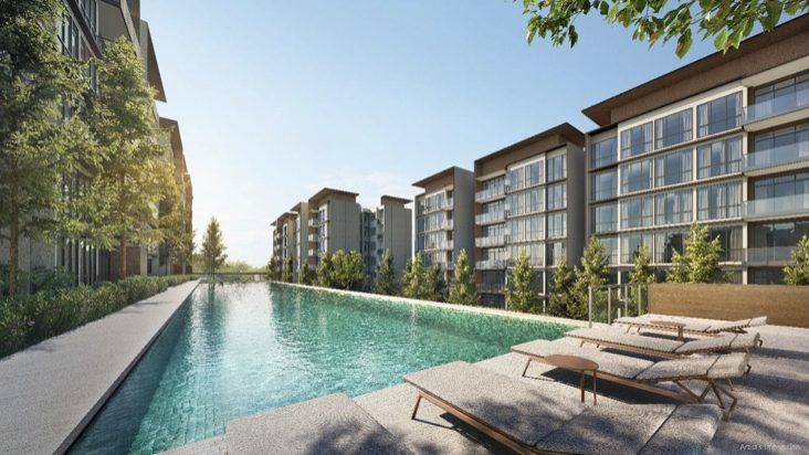 Lakeside lap pool with sun loungers alongside the residential blocks